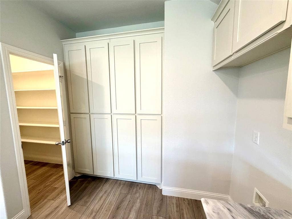 3806 Chicory Court, Melissa, TX 75454 This kitchen features an incredible amount of storage space throughout, highlighted by elegant floor-to-ceiling cabinetry that maximizes vertical utility and a dedicated pantry equipped with custom-designed built-in shelving for seamless organization and convenience.