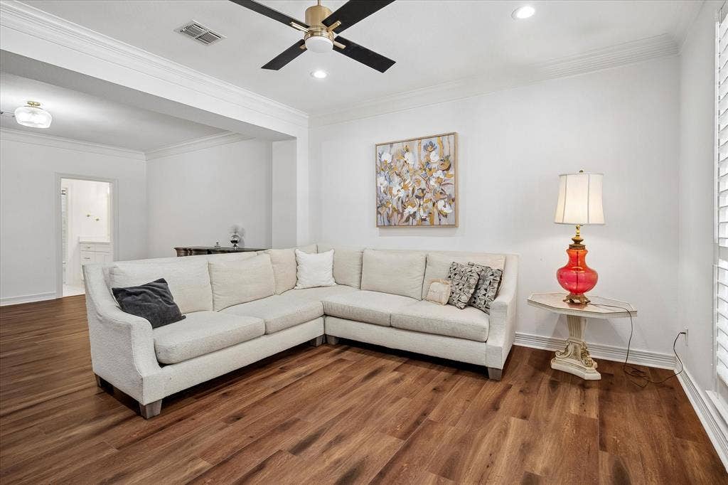 Wood-finish flooring, recessed lighting, ceiling fan, and white plantation shutters