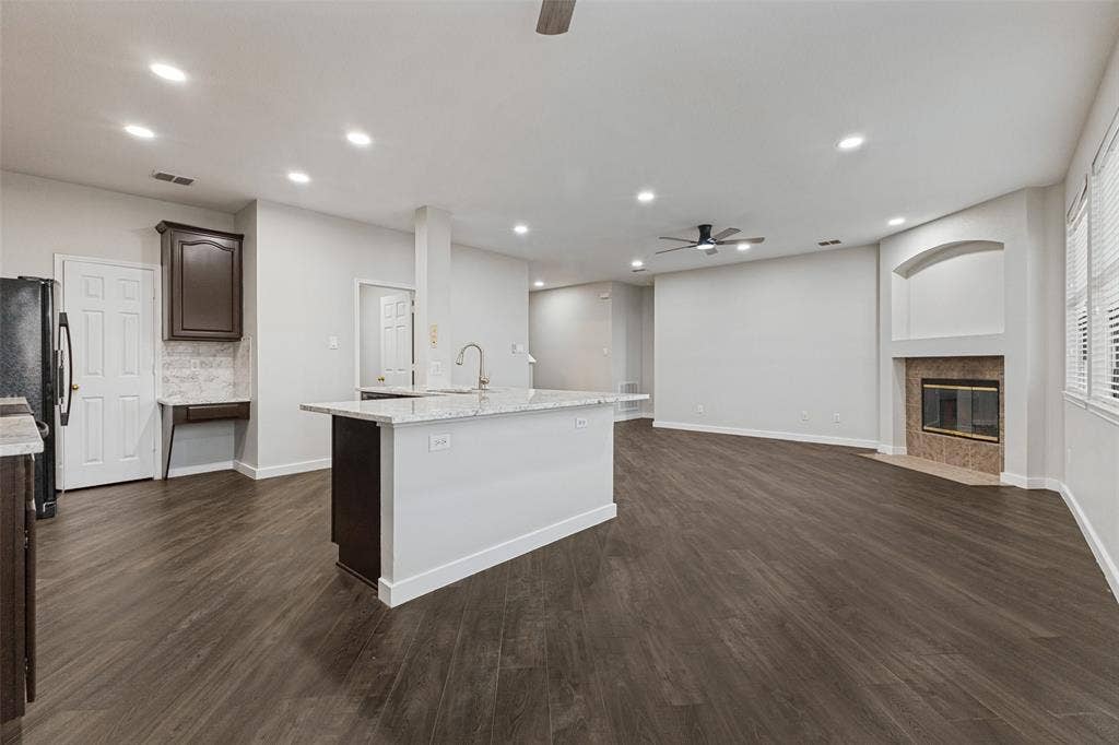 4215 Maidstone Drive, Garland, TX 75043 Open-concept living area featuring wood-finish flooring, recessed lighting, and a kitchen island with a built-in sink