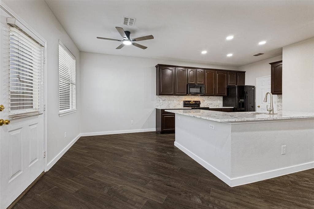 4215 Maidstone Drive, Garland, TX 75043 Open-concept living space featuring wood-finish flooring, recessed lighting, a ceiling fan, dark wood cabinetry, and light-toned countertops