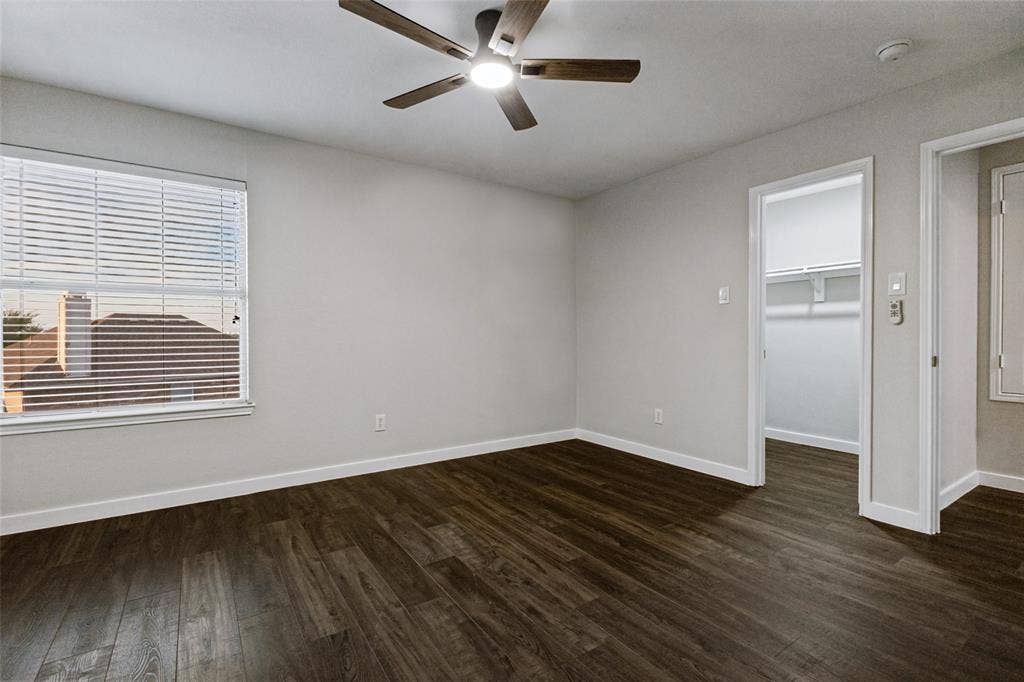 4215 Maidstone Drive, Garland, TX 75043 Wood-finish flooring, ceiling fan with integrated lighting, window with blinds, and a built-in closet with shelving and hanging space