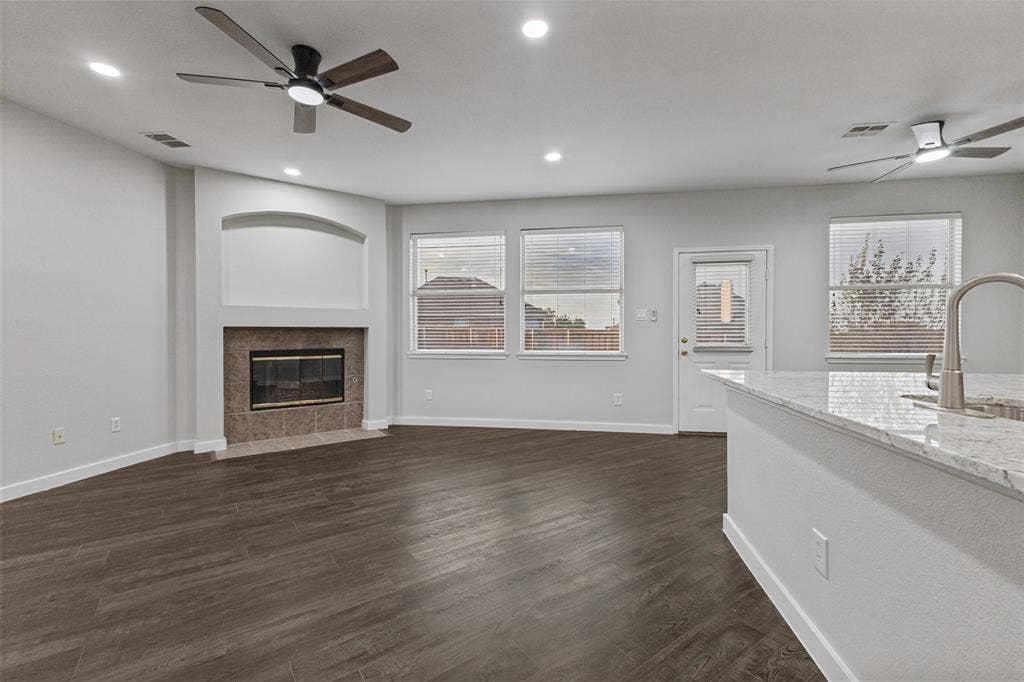 4215 Maidstone Drive, Garland, TX 75043 Living area with wood-finish flooring, a fireplace featuring a tiled surround, recessed lighting, and ceiling fans