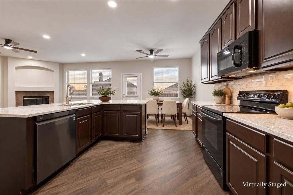4215 Maidstone Drive, Garland, TX 75043 Kitchen featuring dark wood cabinetry, light-toned countertops, integrated stainless steel dishwasher, and black appliances