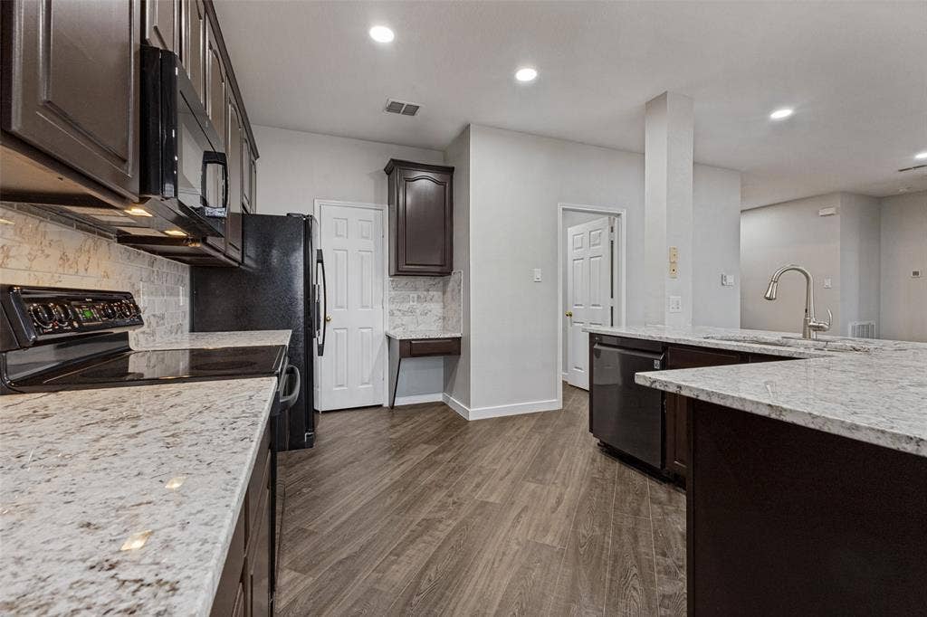 4215 Maidstone Drive, Garland, TX 75043 Kitchen featuring dark wood-finish cabinetry, light-toned countertops, a built-in microwave, an integrated dishwasher, and wood-finish flooring