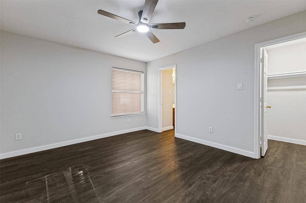 4215 Maidstone Drive, Garland, TX 75043 Wood-finish flooring, overhead lighting with a ceiling fan, window with horizontal blinds, and a built-in closet with shelving