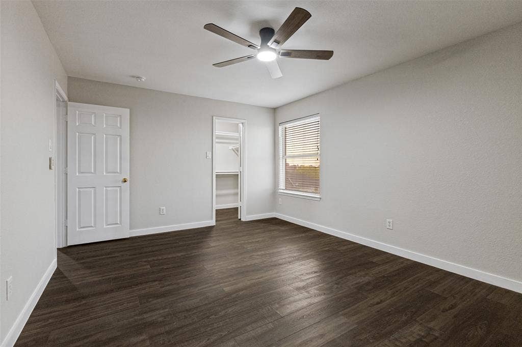 4215 Maidstone Drive, Garland, TX 75043 Wood-finish flooring throughout, bright white walls, integrated ceiling fan with lighting, window with blinds, and an open closet with shelving