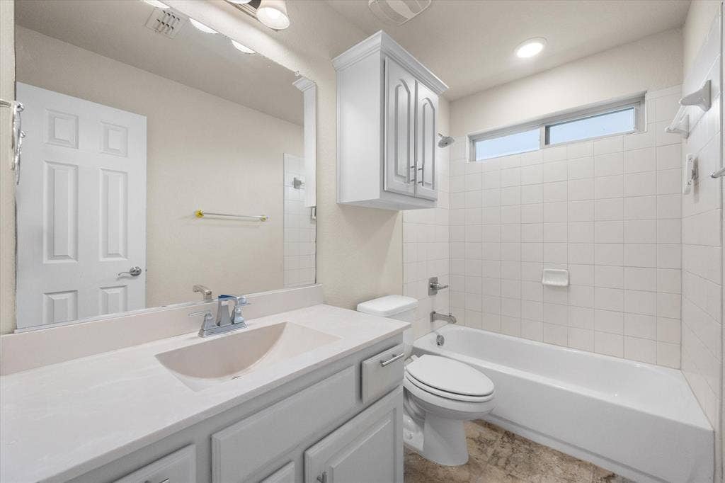 Vanity with integrated sink, white cabinetry, and polished chrome fixtures