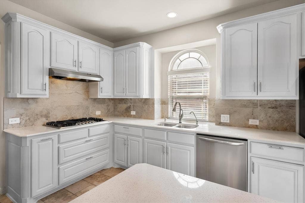 Kitchen featuring white cabinetry, stone-finish countertops, stainless steel appliances, a gas cooktop, and a tile backsplash