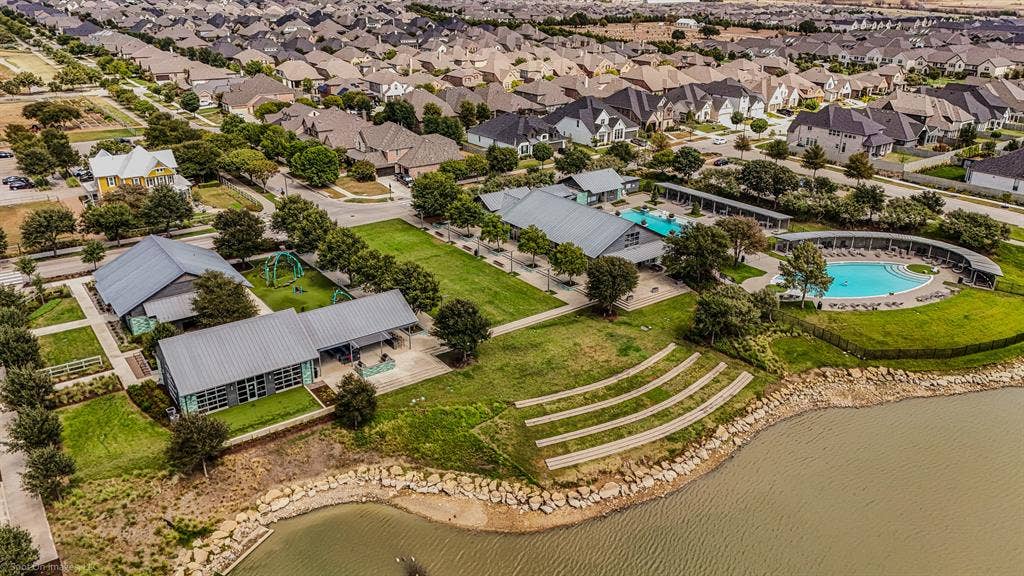 Outdoor amphitheaters and covered gathering spaces along with Two large pools with the large pond at the Amenity Center South located in Argyle, Texas in Harvest by Hillwood for 1302 20th St. in Denton County. Both of these amenity centers have state of the art workout centers.