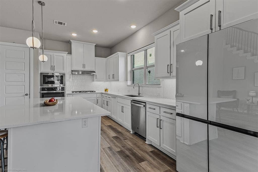 Large kitchen with white cabinets and countertops of 1302 20th St, Argyle, TX in Harvest by Hillwood