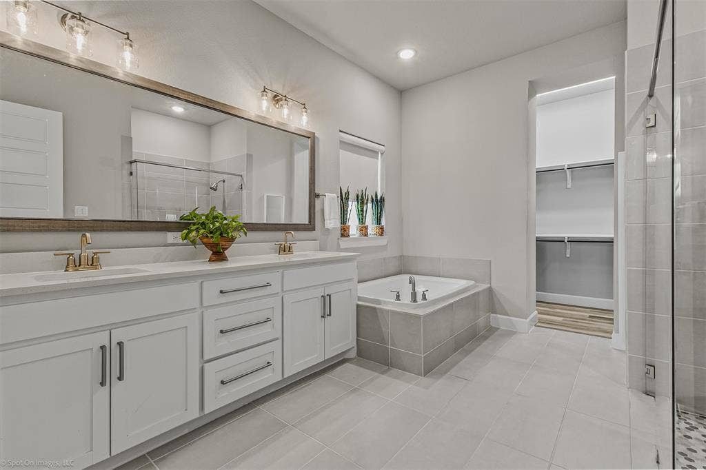 Primary ensuite bathroom with dual sinks, garden rub, and separate shower of 1302 20th St, Argyle, TX in Harvest by Hillwood