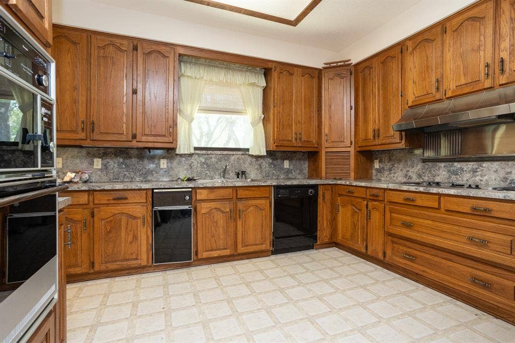 2300 W MAIN Street, Lancaster, TX 75146 Custom wood cabinets with sink under window. Appliance garage for your small items.