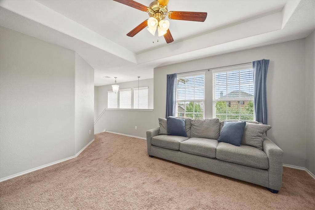 1225 Honeywood Lane, Royse City, TX 75189 Tray ceiling with a ceiling fan, carpeted flooring, and multiple windows with blinds
