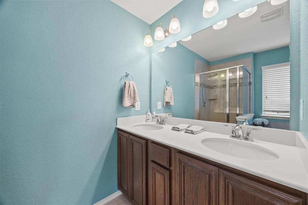 1225 Honeywood Lane, Royse City, TX 75189 Dual vanity with integrated sinks, chrome faucets, and wood-finish cabinetry