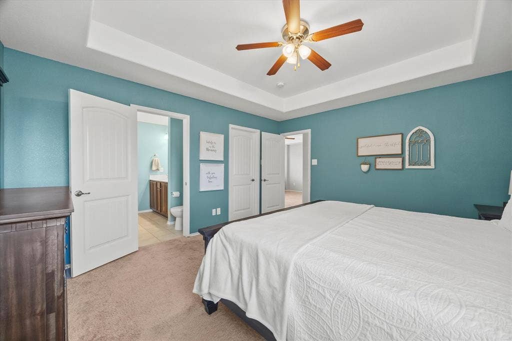 1225 Honeywood Lane, Royse City, TX 75189 Tray ceiling, ceiling fan with light fixture, carpeted flooring, wood-finish doors, and an attached bathroom with a single vanity