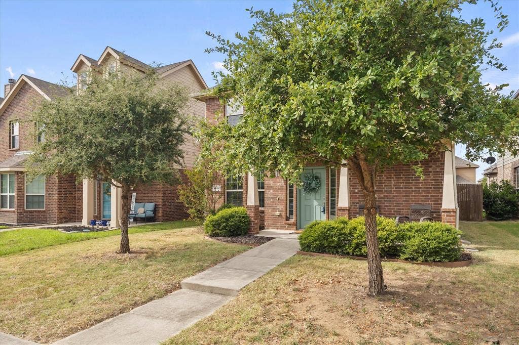 1225 Honeywood Lane, Royse City, TX 75189 Brick exterior, light blue entry door, concrete pathway, mature trees, manicured shrubs