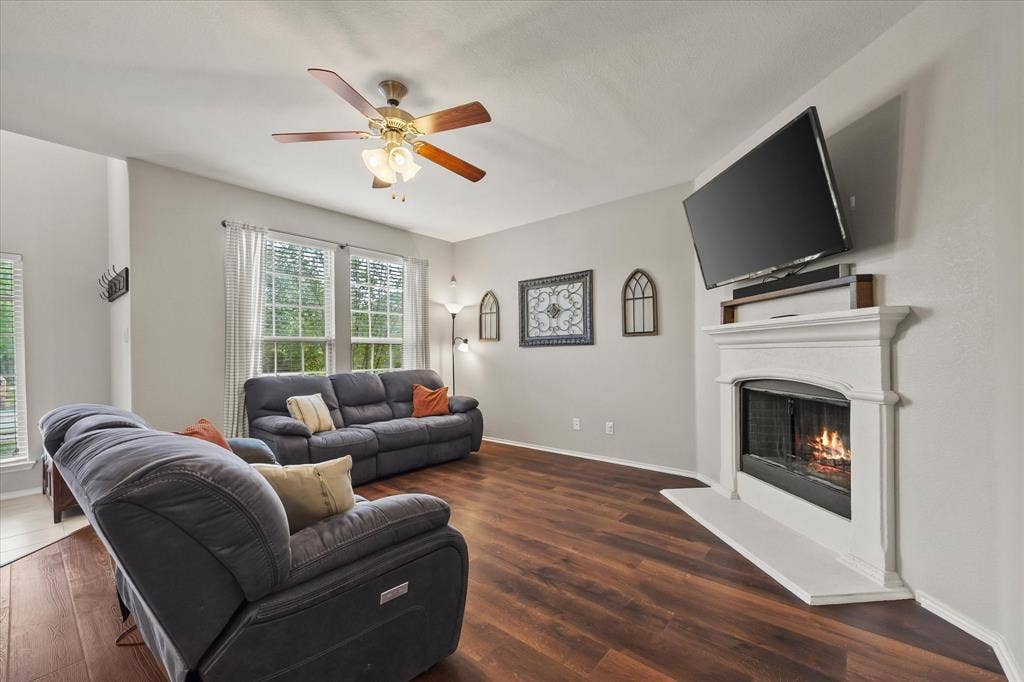 1225 Honeywood Lane, Royse City, TX 75189 Living area featuring wood-finish flooring, a white mantel fireplace, and multiple windows