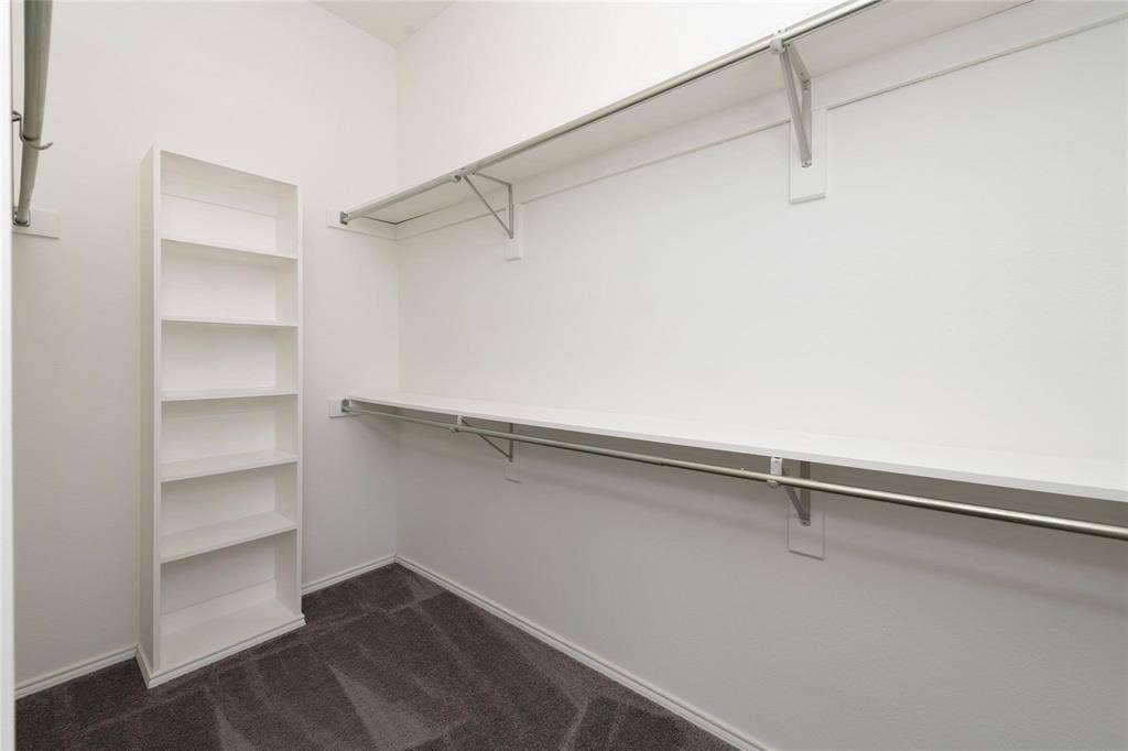 11443 Waterford Lane, Frisco, TX 75035 White shelving system, dual hanging rods, upper storage shelf, and carpeted flooring