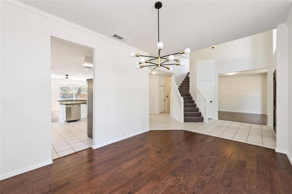 11443 Waterford Lane, Frisco, TX 75035 Dark wood-finish flooring, contemporary chandelier, white tile flooring, carpeted staircase, and stainless steel appliances