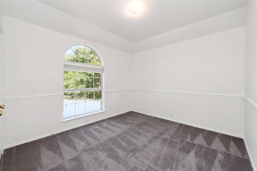 11443 Waterford Lane, Frisco, TX 75035 Room featuring an arched window, white walls, and wainscoting