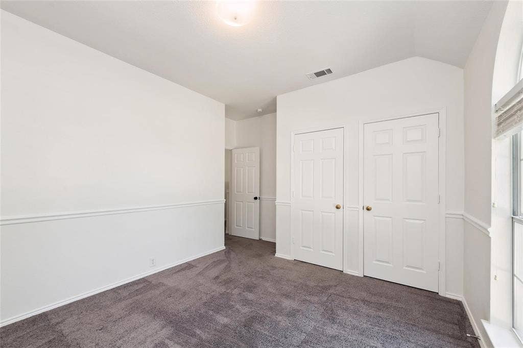 11443 Waterford Lane, Frisco, TX 75035 Plush gray carpet flooring, white paneled doors, wainscoting, and an arched window