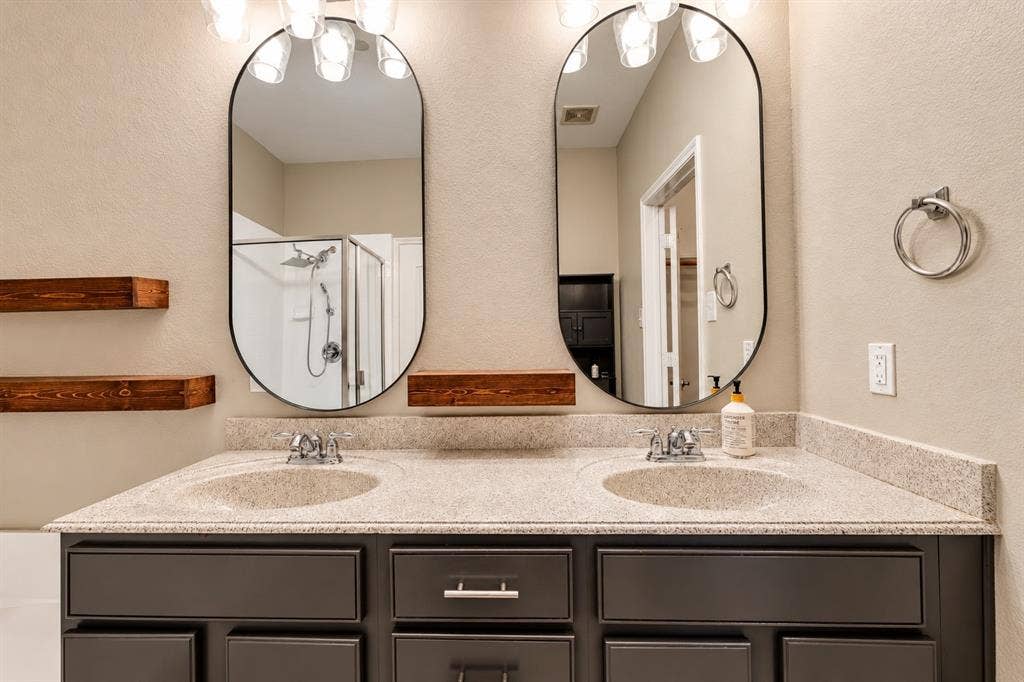 6854 Cortona Lane, Frisco, TX 75034 Dual vanity with a speckle-patterned countertop, under-mount sinks, and chrome-finish faucets