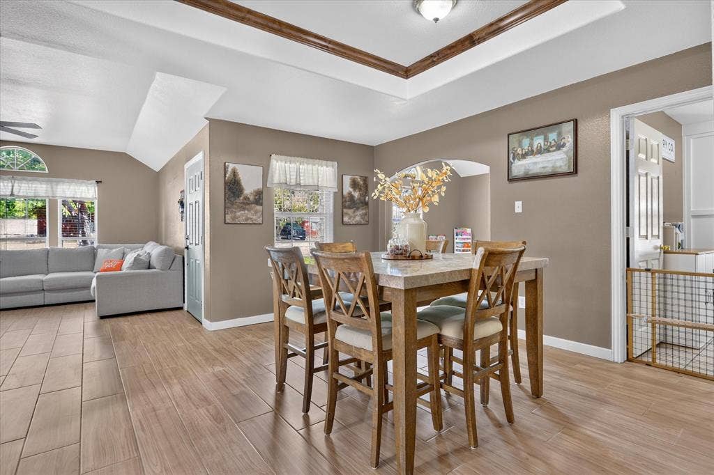 5413 Cornell Avenue, River Oaks, TX 76114 Tray ceiling with wood-finish trim, wood-look tile flooring, arched doorway, and recessed lighting fixture