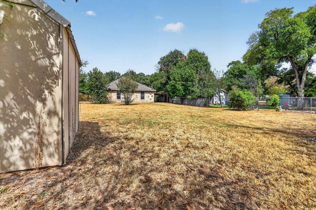 5413 Cornell Avenue, River Oaks, TX 76114 Expansive backyard featuring a storage shed, established trees, and a chain-link fence