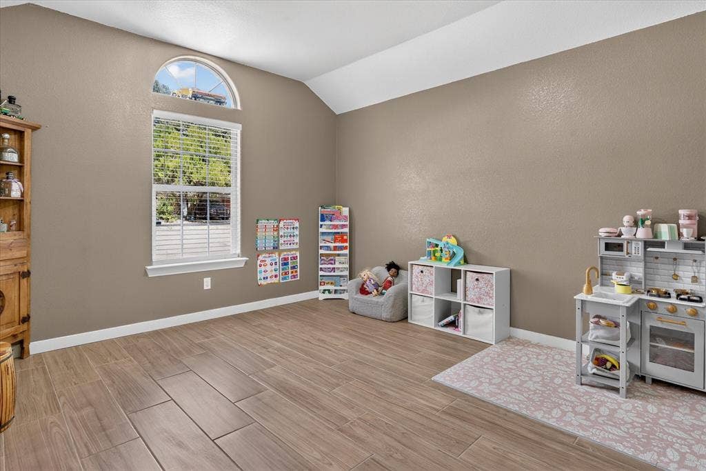 5413 Cornell Avenue, River Oaks, TX 76114 Vaulted ceiling with a half-round transom window, wood-finish flooring, and crisp white trim details