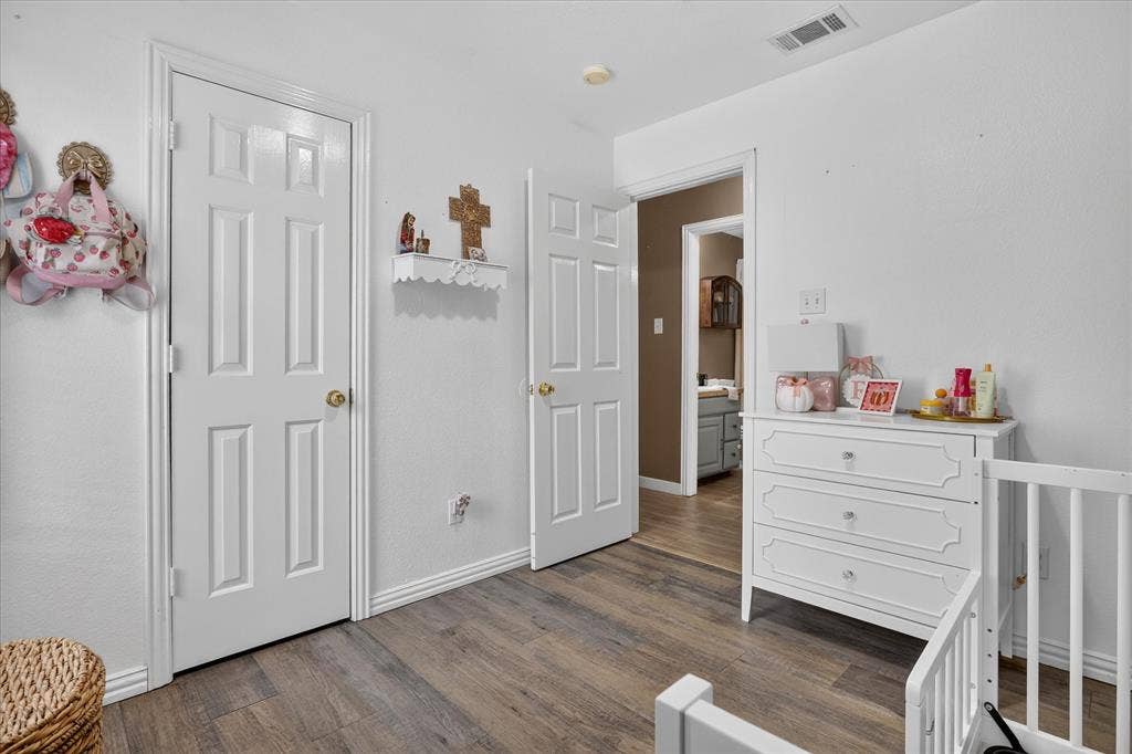 5413 Cornell Avenue, River Oaks, TX 76114 Wood-finish flooring with white baseboards and trim