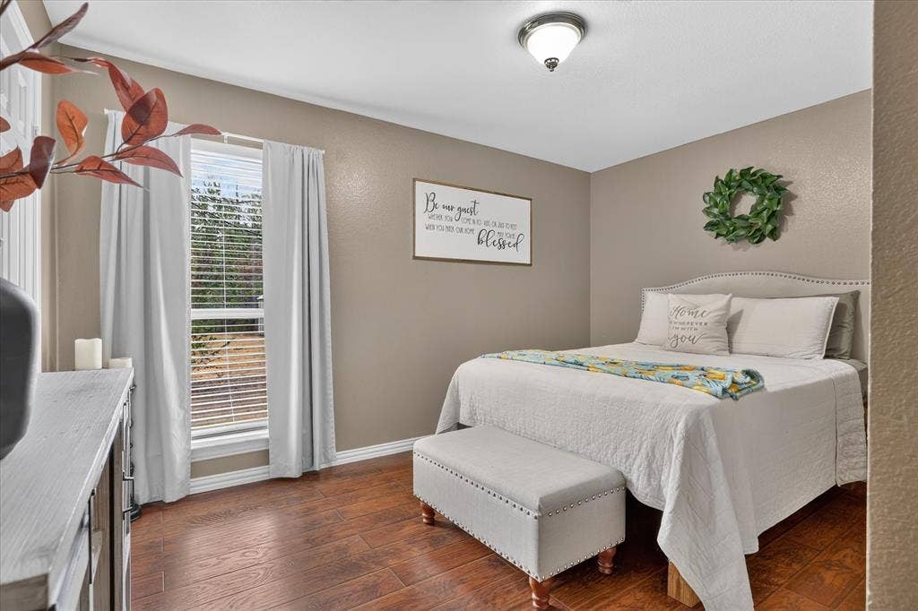 5413 Cornell Avenue, River Oaks, TX 76114 Wood-finish flooring, single window with blinds, recessed lighting fixture, upholstered headboard with nailhead trim