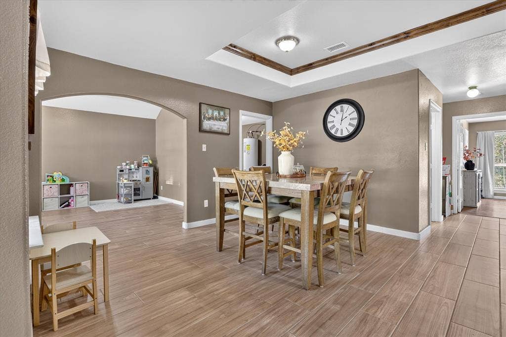 5413 Cornell Avenue, River Oaks, TX 76114 Wood-finish flooring throughout, tray ceiling with wood-clad trim, recessed lighting, and arched doorway