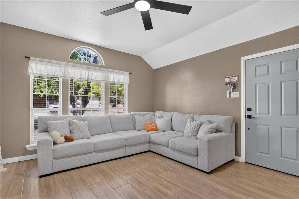 5413 Cornell Avenue, River Oaks, TX 76114 Vaulted ceiling with a black ceiling fan, wood-finish flooring, and a window with an arched transom