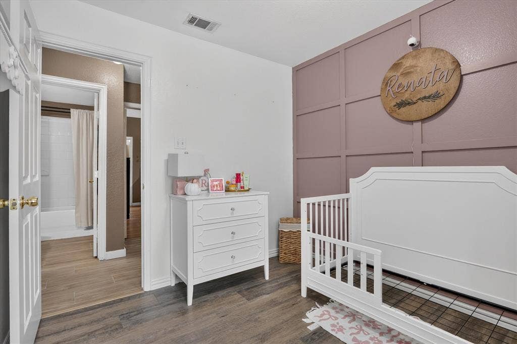 5413 Cornell Avenue, River Oaks, TX 76114 Wood-finish flooring throughout, with a feature wall showcasing wainscoting and painted paneling
