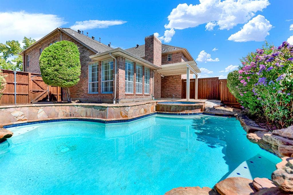4020 MAYFLOWER Lane, Plano, TX 75024 Bright blue water reflects crisp skies beside vibrant flowering crepe myrtles along the fence line. Host unforgettable weekend pool parties for family and friends all season long.