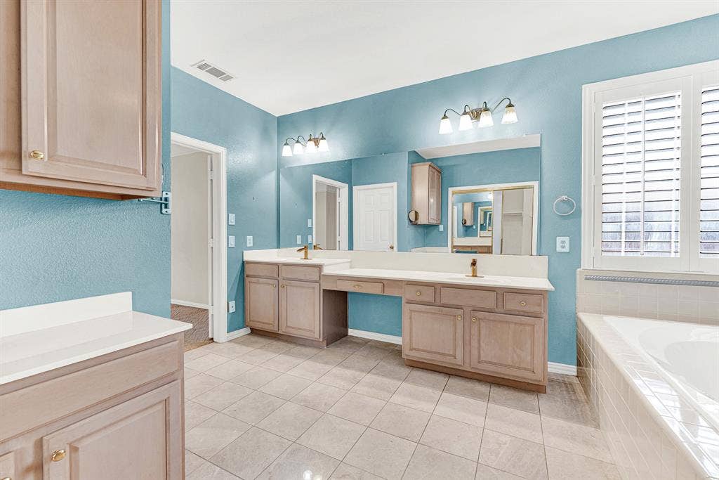 4020 MAYFLOWER Lane, Plano, TX 75024 An expansive dual-sink vanity features a built-in makeup station beneath bright vanity lights. Enjoy a smooth, unhurried morning routine side-by-side