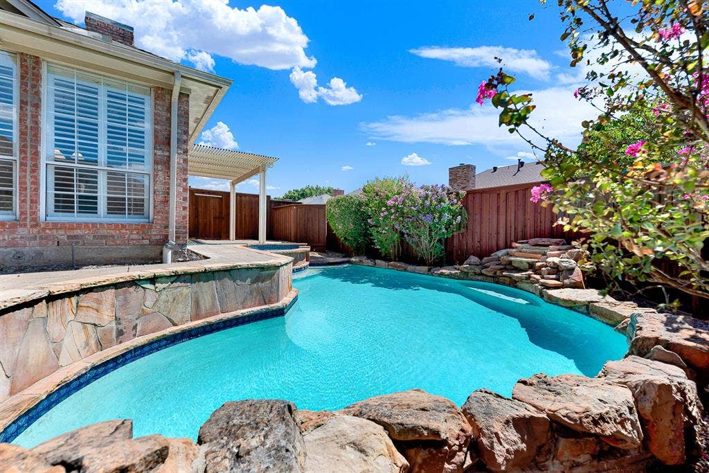 4020 MAYFLOWER Lane, Plano, TX 75024 Natural stone rockwork and a gentle waterfall accent the edge of this private backyard pool oasis. Listen to the soothing sound of trickling water while basking in the sun