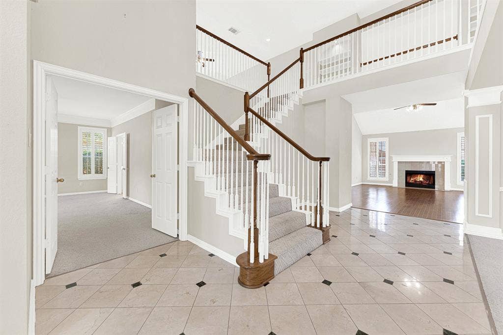 4020 MAYFLOWER Lane, Plano, TX 75024 A grand two-story entry foyer features polished tile floors, classic wood banisters, and direct views into adjacent living spaces. Welcome guests into an impressive, light-filled greeting space that sets a welcoming tone