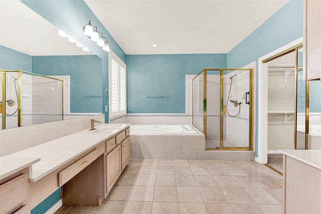 4020 MAYFLOWER Lane, Plano, TX 75024 A deep soaking tub and glass shower stall are nestled against tranquil sky-blue walls. Treat yourself to a relaxing spa-like bath at the end of the wee