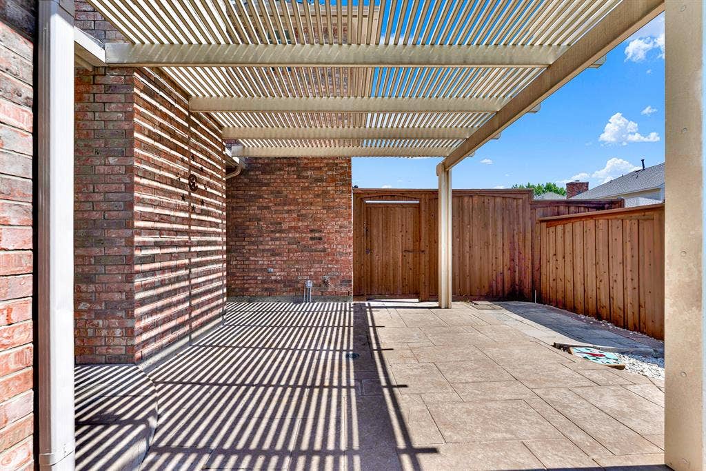 4020 MAYFLOWER Lane, Plano, TX 75024 A covered pergola extends over the paved patio area, offering shaded seating surrounded by private wood fencing. Perfect for grilling out or dining alfresco on warm summer afternoons.