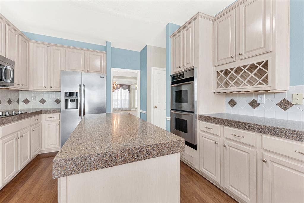 4020 MAYFLOWER Lane, Plano, TX 75024 A built-in double oven and lattice wine rack seamlessly anchor the functional prep perimeter. Imagine uncorking a favorite vintage while simmering sauce on a relaxing evening.