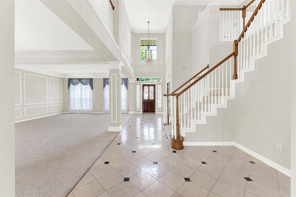 4020 MAYFLOWER Lane, Plano, TX 75024 Soaring two-story ceilings and polished tile floors reflect light throughout this open entry, anchored by a traditional wooden staircase. It’s the perfect spot to warmly welcome guests as they arrive for an evening celebration.