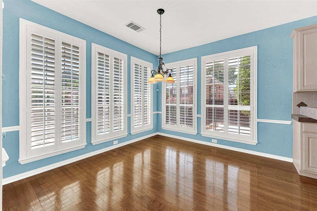 4020 MAYFLOWER Lane, Plano, TX 75024 Tall plantation shutters wrap this sunlit corner room beneath an elegant wrought-iron fixture. Sip warm tea while watching the backyard garden wake up in the morning sun.
