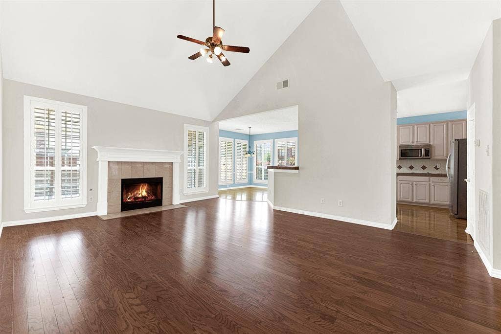 4020 MAYFLOWER Lane, Plano, TX 75024 A dramatic vaulted ceiling draws the eye upward while a central tile hearth casts a warm glow across glowing wood floors. Picture curling up here with a mug of hot cocoa on a crisp autumn evening.