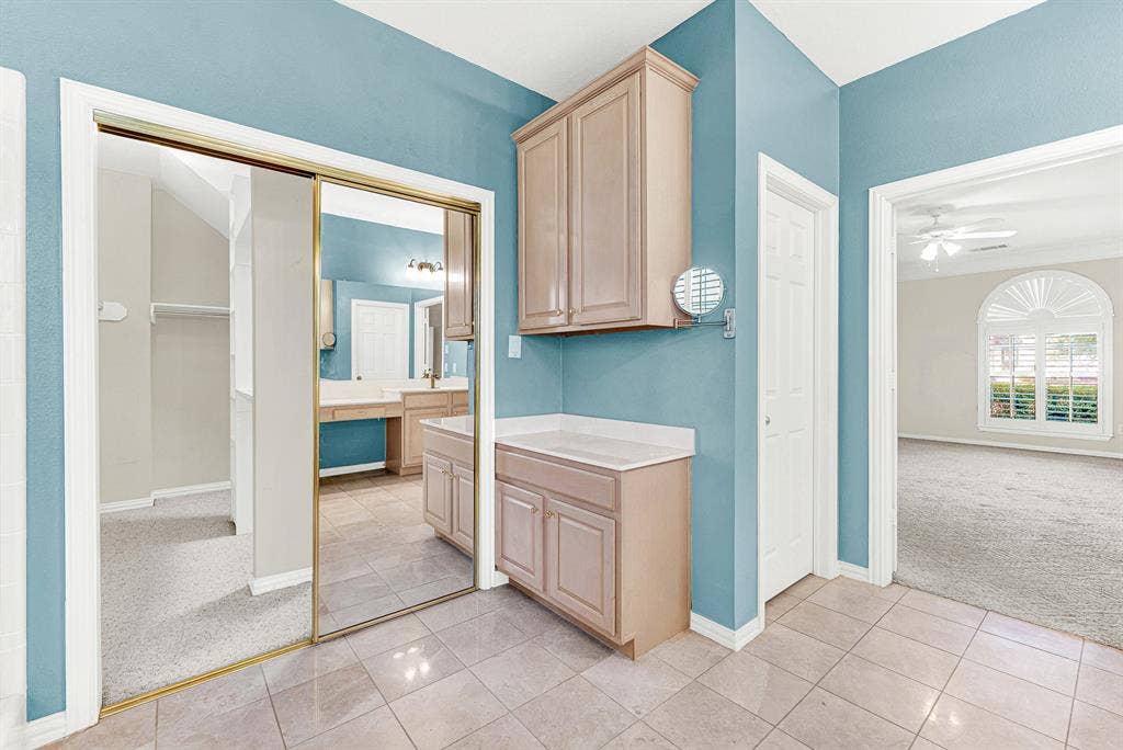 4020 MAYFLOWER Lane, Plano, TX 75024 Mirrored closet doors expand the tiled dressing area near the primary bedroom entrance. Get ready effortlessly with extra storage right at your fingertips.