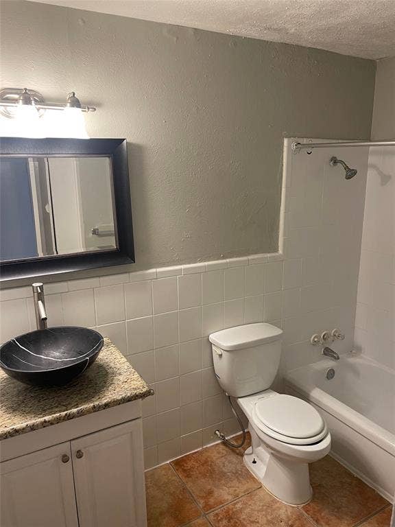 5317 Junius Street, #214, Dallas, TX 75214 Vanity with a vessel sink, stone-look countertop, and white cabinetry