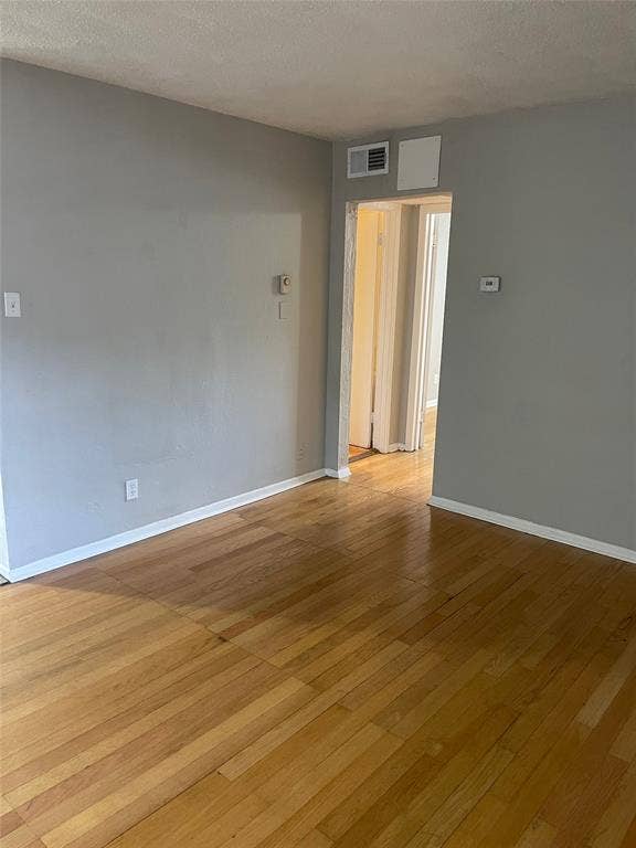 5317 Junius Street, #214, Dallas, TX 75214 Wood-finish flooring with white trim and light gray walls