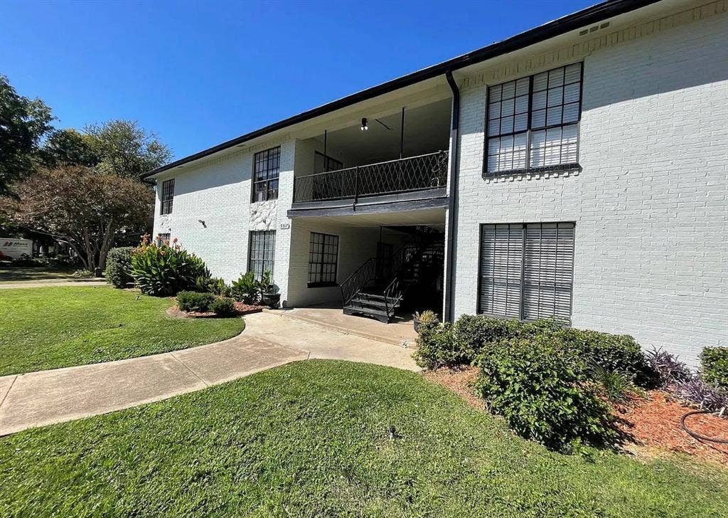 5317 Junius Street, #214, Dallas, TX 75214 Brick exterior with a second-story balcony featuring an ornamental iron railing