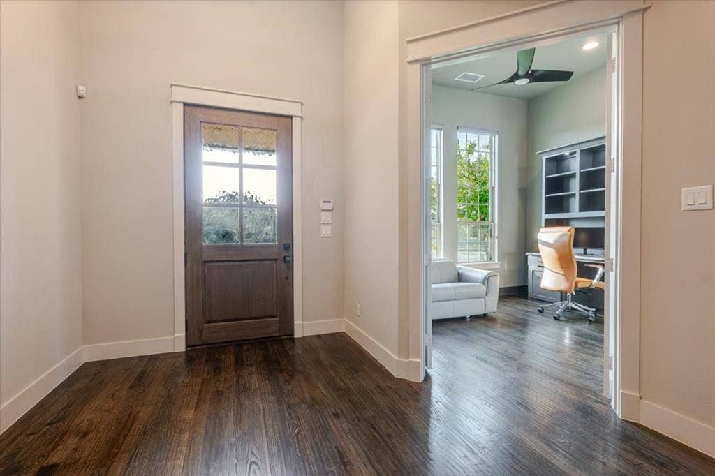 4102 Parkview Boulevard, Celina, TX 75009 Wood-finish flooring throughout, solid wood entry door with glass panels, room with built-in shelving, windows providing natural light, and a ceiling fan