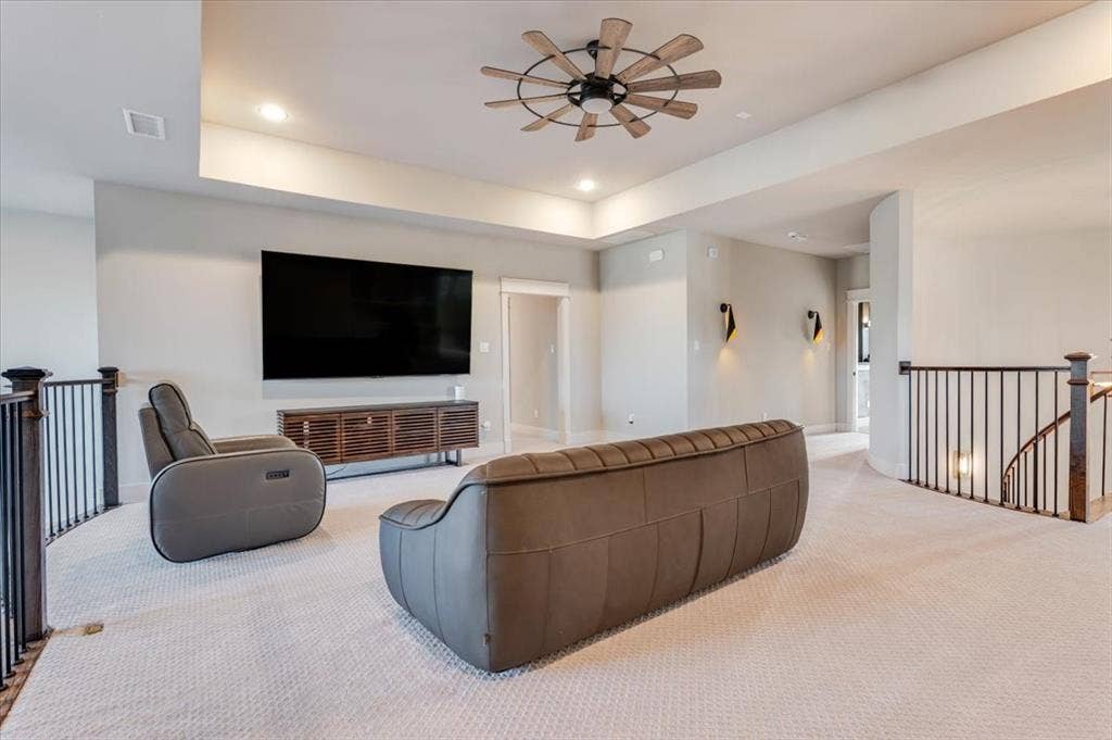 4102 Parkview Boulevard, Celina, TX 75009 Recessed ceiling with integrated lighting, wood-finish ceiling fan, wrought iron stair railing, and wall-mounted sconces